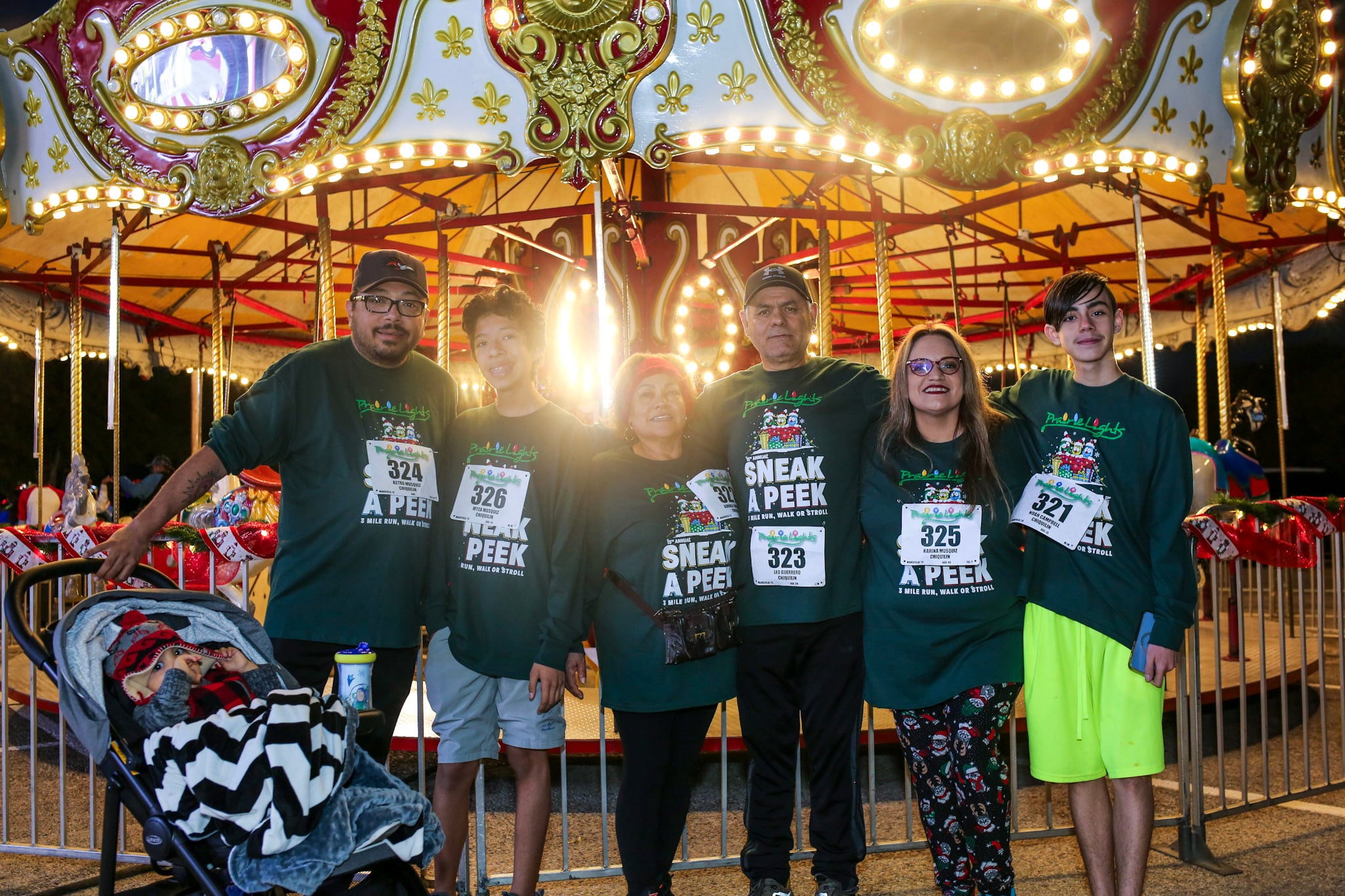 Families riding a lit carousel at Prairie Lights